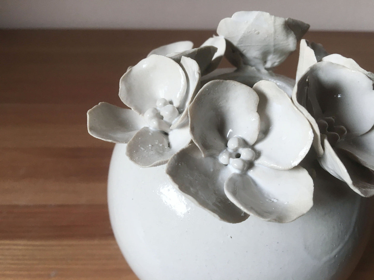 Vaso sferico bianco in gres con fiori a 4 petali