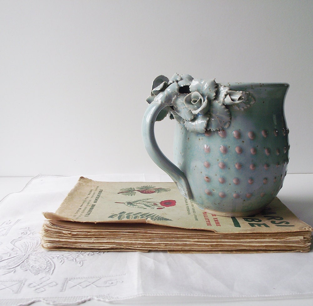 Tazza Alice in gres azzurro con rose bianche e puntini rosa in rilievo, fatta a mano al tornio
