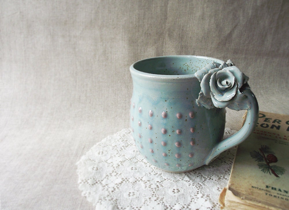 Tazza Alice in gres azzurro con rose bianche e puntini rosa in rilievo, fatta a mano al tornio