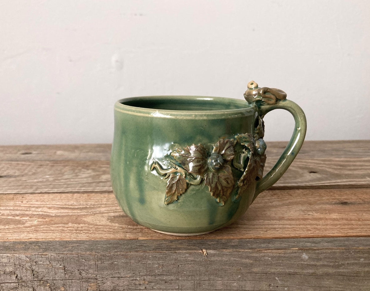 tazza artigianale con decorazione rana e more, colore verde lucido