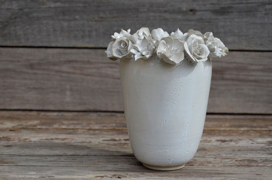 Vaso alto bianco in gres con una corolla di fiori misti sulla sommità